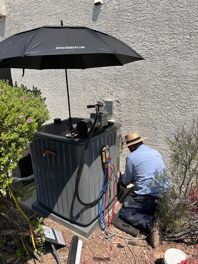HVAC technician performing outdoor AC maintenance in Paris